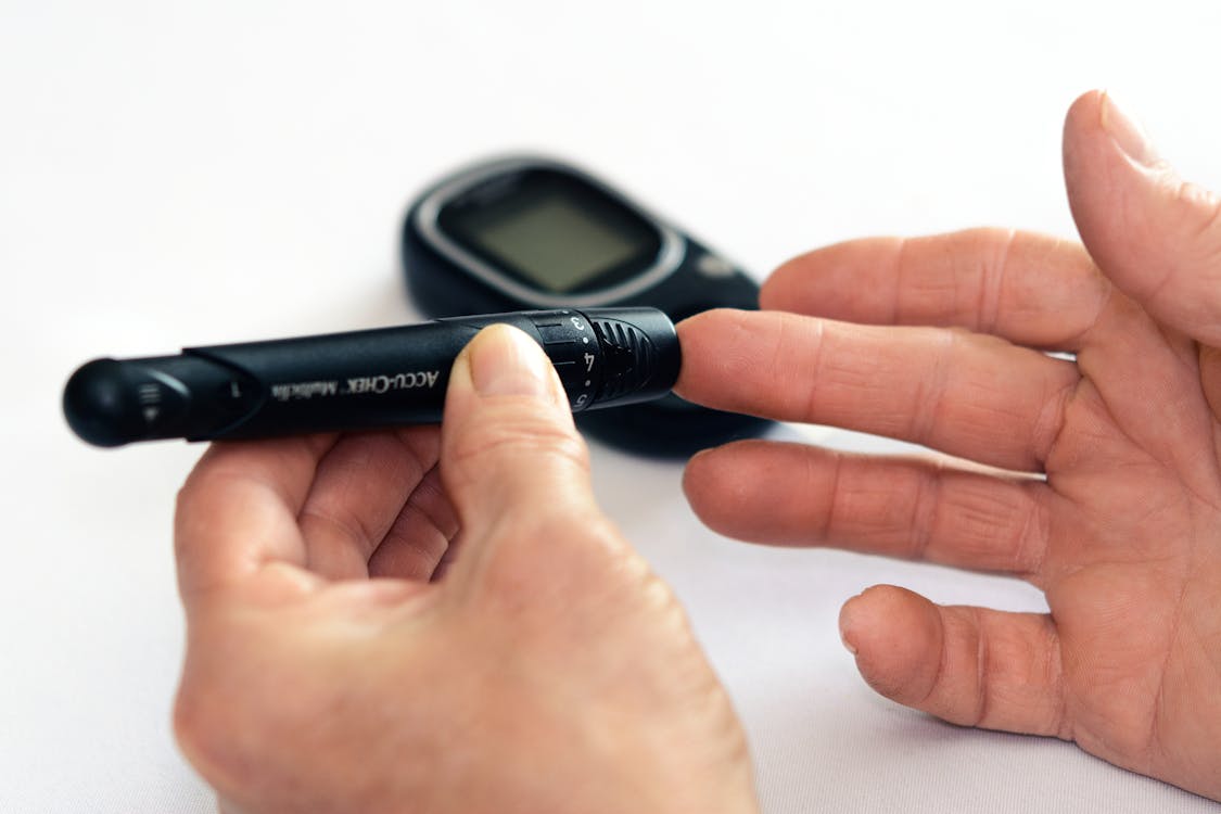 Person checking blood glucose with a finger stick glucometer
